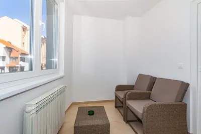 two chairs and a table in a room with a window at Apartman Krželj B2 in Livno