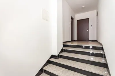 a hallway with black and white stairs and a door at Apartman Krželj B2 in Livno