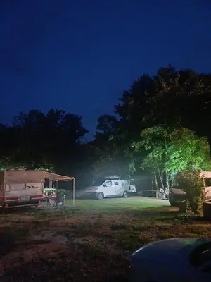 a white car parked in a field at night at AutoCamp Aqualand in Bihać
