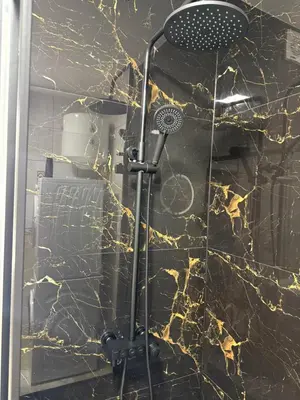 a shower in a bathroom with a marble wall at Luxury Apartment Tuzla in Tuzla