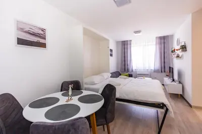 a room with a bed and a table and chairs at Apartman Krželj B3 in Livno