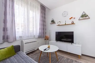 a living room with a couch and a tv and a table at Apartman Krželj B3 in Livno