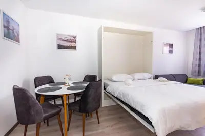 a bedroom with a bed and a table and chairs at Apartman Krželj B3 in Livno