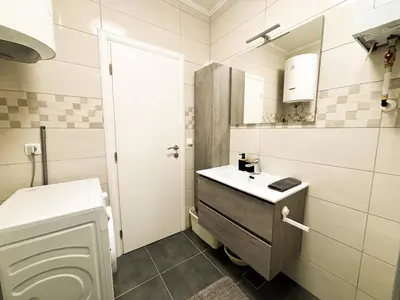 a white bathroom with a sink and a toilet at Apartman Sučić in Livno