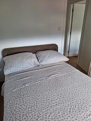 a bed with a white comforter and two pillows at Apartman Una banjaluka in Hiseti