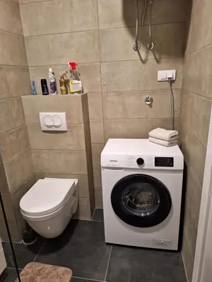 a bathroom with a washing machine and a toilet at Apartman Una banjaluka in Hiseti