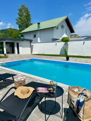 a table with a hat sitting next to a swimming pool at Unavis Residence in Bihać