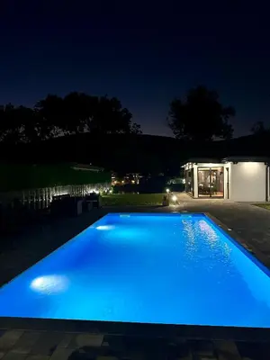 a large blue swimming pool at night at Unavis Residence in Bihać
