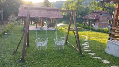 a swing set in a yard with a gazebo at Vikendica Krupa na Vrbasu in Banja Luka