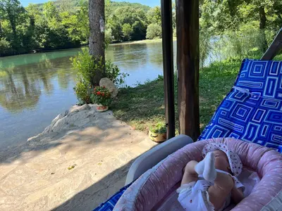 a baby is laying in a inflatable bed next to a river at Vikendica Krupa na Vrbasu in Banja Luka