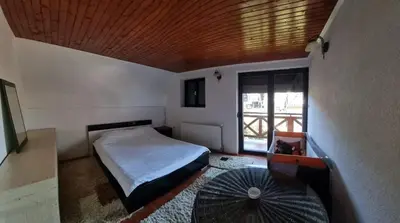 a small bedroom with a bed and an umbrella at A&S vikendica Vlašić in Šišava