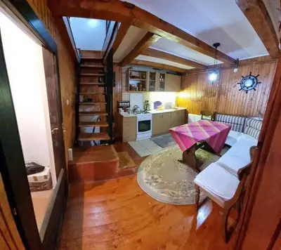 a living room with a staircase and a kitchen at A&S vikendica Vlašić in Šišava