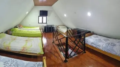 a attic room with two beds and a staircase at A&S vikendica Vlašić in Šišava