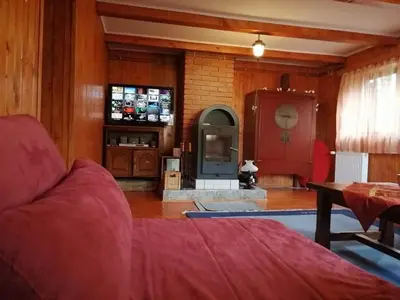 a living room with a red couch and a fireplace at A&S vikendica Vlašić in Šišava