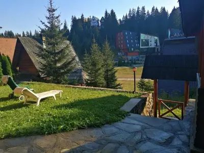 a bench sitting in the grass in a yard at A&S vikendica Vlašić in Šišava