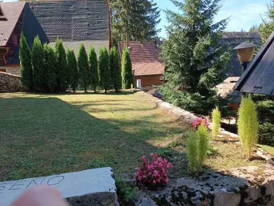a backyard with a yard with trees and plants at A&S vikendica Vlašić in Šišava