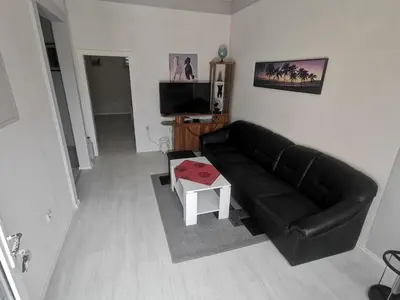a living room with a black leather couch and a table at Apartman Marija in Livno