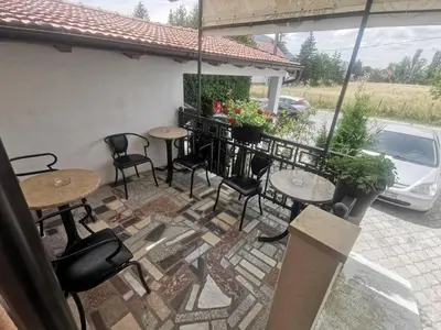 a patio with tables and chairs and a car at Apartman Marija in Livno