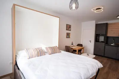 a bedroom with a large white bed and a table at Apartman Krželj B1 in Livno