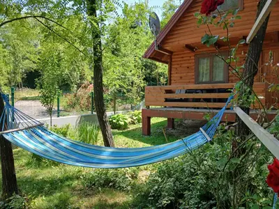 a hammock in front of a log cabin at Pure Nature in Bihać