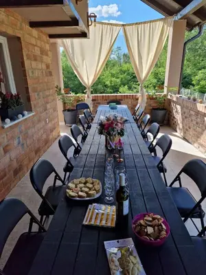 a long table with food and wine on a patio at Vikendica Villa Ramona Banja Luka in Banja Luka