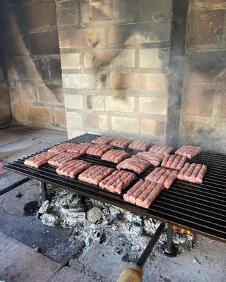 a bunch of sausages cooking on a grill at Vikendica Villa Ramona Banja Luka in Banja Luka