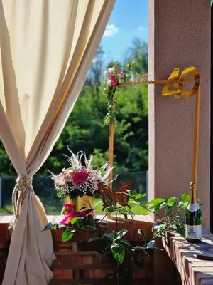 a window with flowers on a ledge with a curtain at Vikendica Villa Ramona Banja Luka in Banja Luka