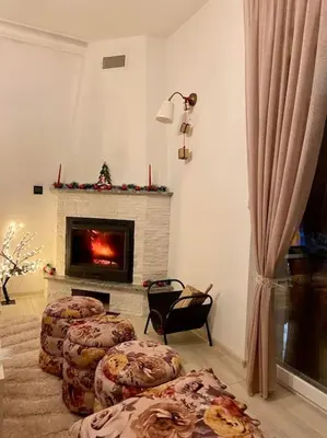 a living room with three stools in front of a fireplace at Farmhouse Dženi in Vlasic