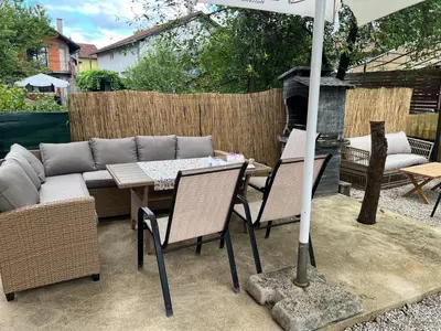 a patio with a couch and chairs and an umbrella at Una in Bihać
