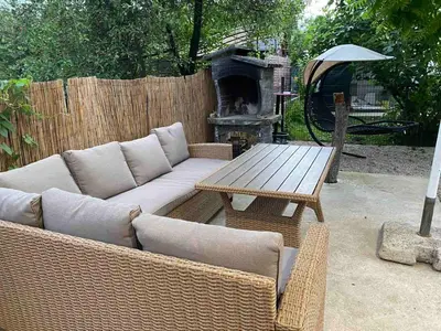 a couch and a table with a fireplace in a backyard at Una in Bihać
