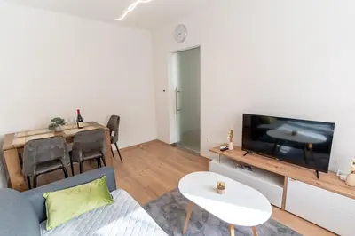a living room with a couch and a tv and a table at Apartman Krželj B4 in Livno