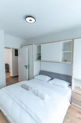 a bedroom with a large white bed with white pillows at Apartman Krželj B4 in Livno