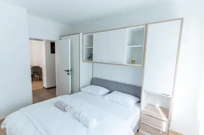 a bedroom with a white bed with white pillows at Apartman Krželj B4 in Livno