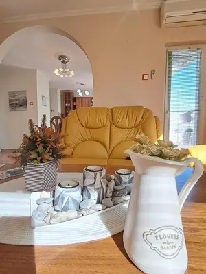 a living room with a couch and a vase on a table at Apartman Ajla in Bihać