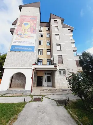 a tall building with a large sign on it at Apartman Ajla in Bihać