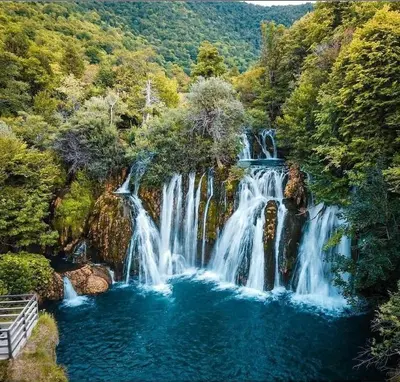 a waterfall in the middle of a forest at Apartman Ajla in Bihać