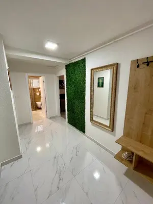 a living room with a mirror and a green wall at ANET Apartman Visoko in Visoko