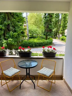 a patio with two chairs and a table and a window at ANET Apartman Visoko in Visoko