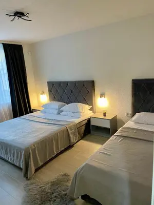 a hotel room with two beds and a window at ANET Apartman Visoko in Visoko