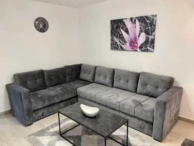 a living room with a leather couch and a table at ANET Apartman Visoko in Visoko
