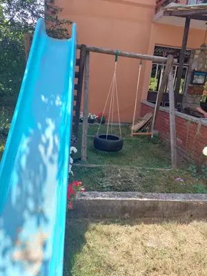 a swing set in a yard with a tire at 33 Lipe in Travnik