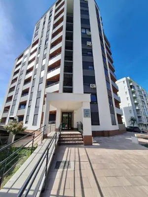 a tall white building with stairs in front of it at Apartmani Sarah 3 Tuzla in Tuzla