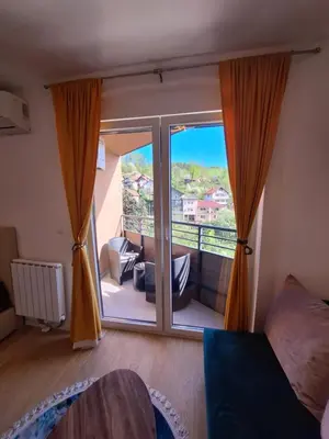 a room with a large window with a view of a balcony at Apartmani Sarah 3 Tuzla in Tuzla