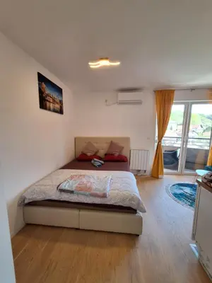 a bedroom with a bed and a large window at Apartmani Sarah 3 Tuzla in Tuzla