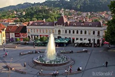 a fountain in a plaza in front of a building at Apartmani Sarah 3 Tuzla in Tuzla