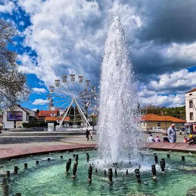 a water fountain in front of a ferris wheel at Apartmani Sarah 3 Tuzla in Tuzla