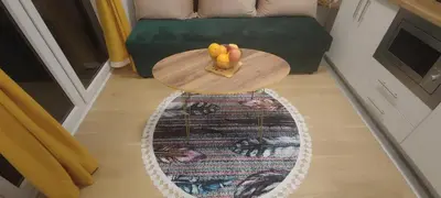 a table with a bowl of fruit on top of a rug at Apartmani Sarah 4 Tuzla in Tuzla