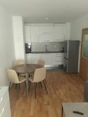 a kitchen with white cabinets and a table and chairs at Ivan in Livno