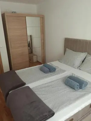 a large bed with two blue pillows on it at Ivan in Livno