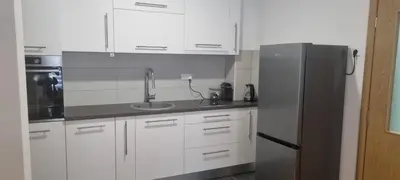a kitchen with white cabinets and a stainless steel refrigerator at Ivan in Livno